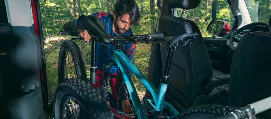 A man storing bikes in the interior of a Volkswagen multivan
