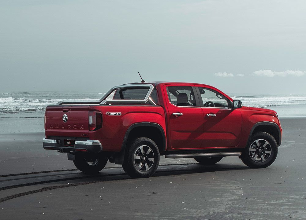 Rear shot of a red ute parked on a beach