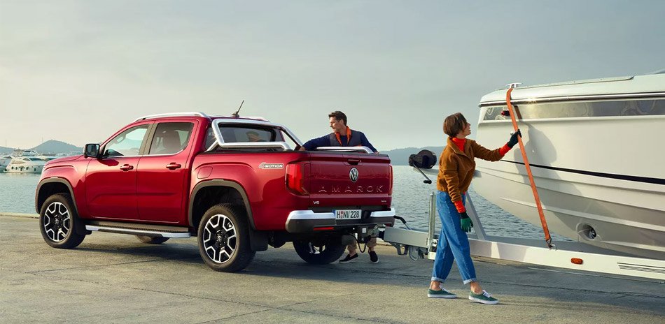 Rear shot of a red ute parked with a botch hitched to the tow bar