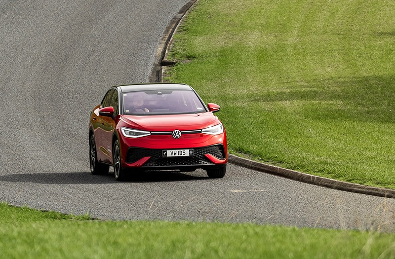 Red electric SUV driving on a road towards the viewer