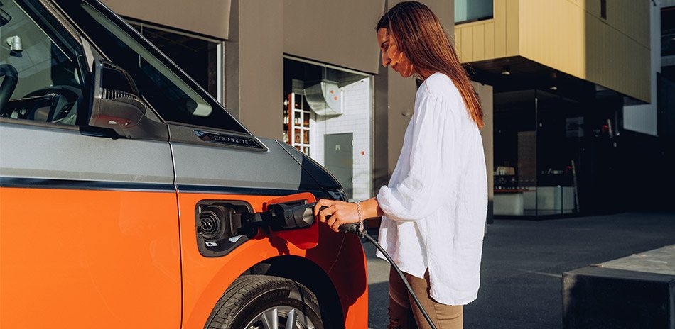 A woman plugging a charger into a van