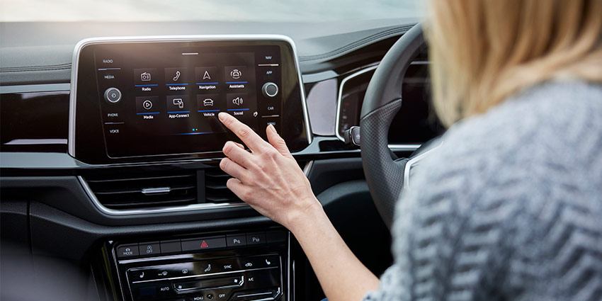 A woman using an infotainment screen in an suv