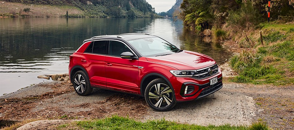A red T-Roc parked by a lake
