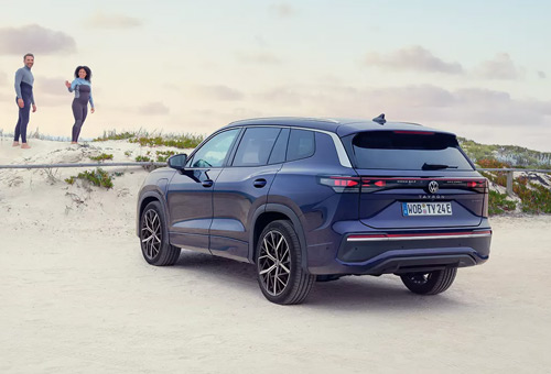 Rear view of a blue Tayron SUV on a beach