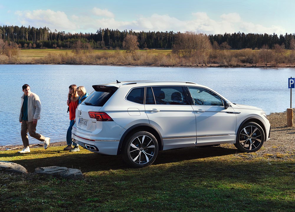 White SUV parked by a lake