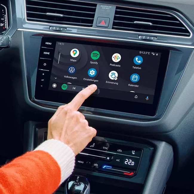 A human hand using the infotainment screen in a Volkswagen