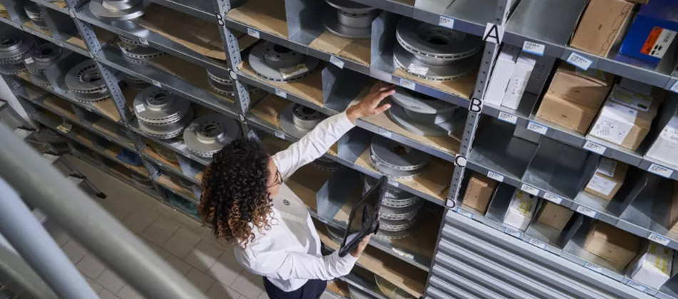 A woman looking through a shelf of vehicle parts
